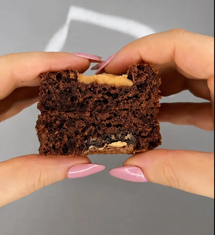 Mãos partindo um brownie ao meio (abre o Instagram)